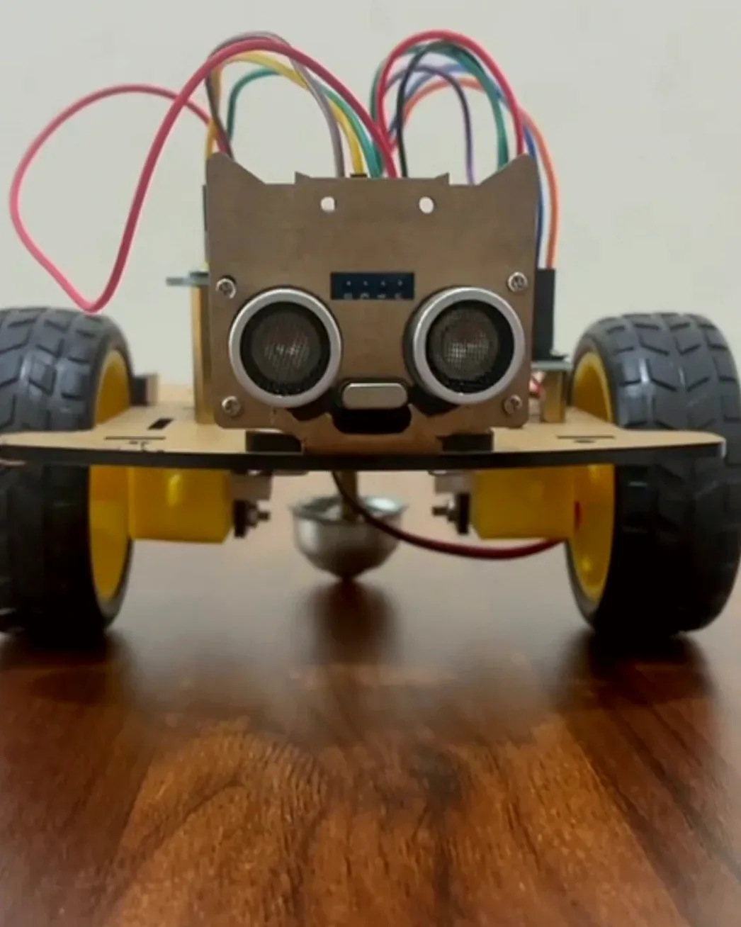 An Arduino robot car seen from the front, with two ultrasonic sensors as eyes